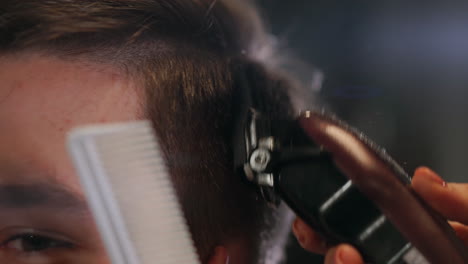 corte de pelo masculino con maquinilla de afeitar eléctrica. primer plano del peinado de cortador de cabello. peluquero profesional cortando el cabello con cortadora de cabello. peluquería masculina con afeitadora eléctrica
