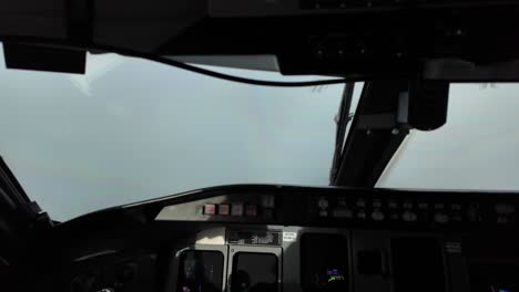 Immersive-pilot-POV-in-a-real-time-flight-through-some-clouds,-with-the-sun-illuminating-flight-instruments