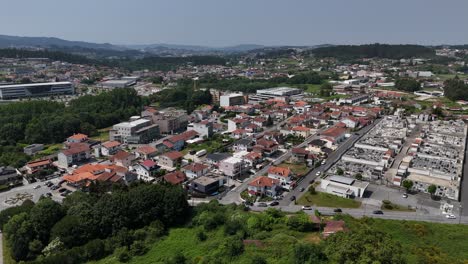 aerial - paços de ferreira town with red rooftops fields cemetery and surrounding hills