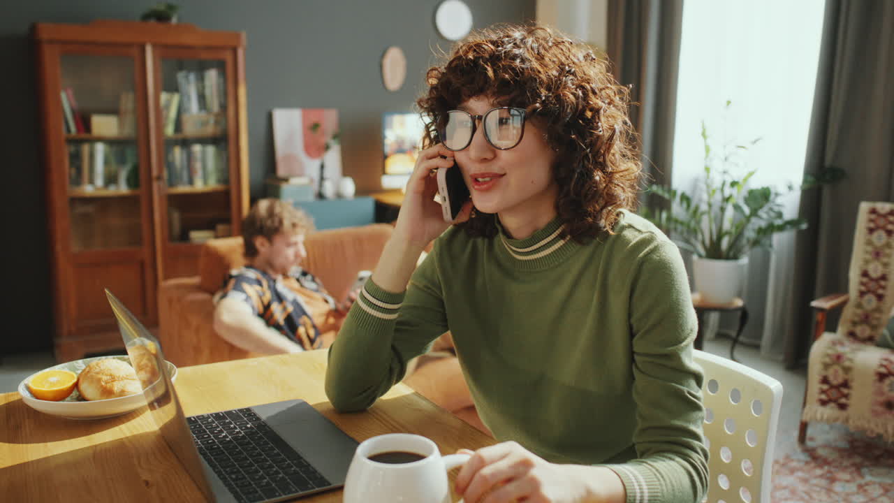Smiling Woman Talking on Phone while Working from Home