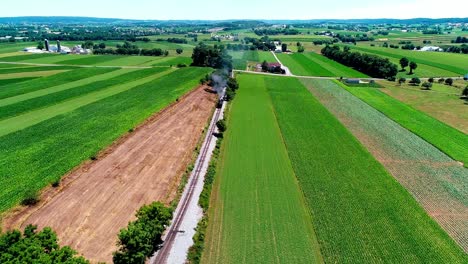 Dampfzug,-Der-An-Einem-Sonnigen-Sommertag-Durch-Amisches-Ackerland-Und-Landschaft-Fährt,-Wie-Von-Der-Drohne-Aus-Gesehen