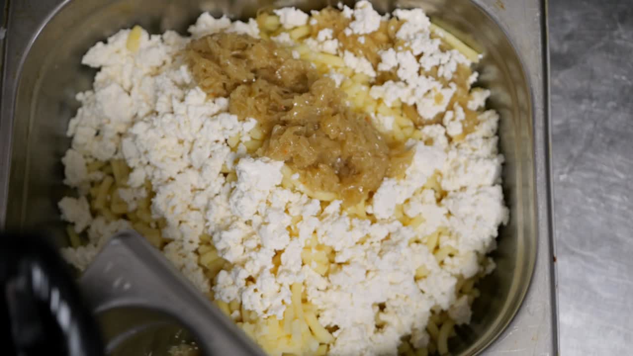 el chef agrega cebollas salteadas al relleno hecho de patatas y queso