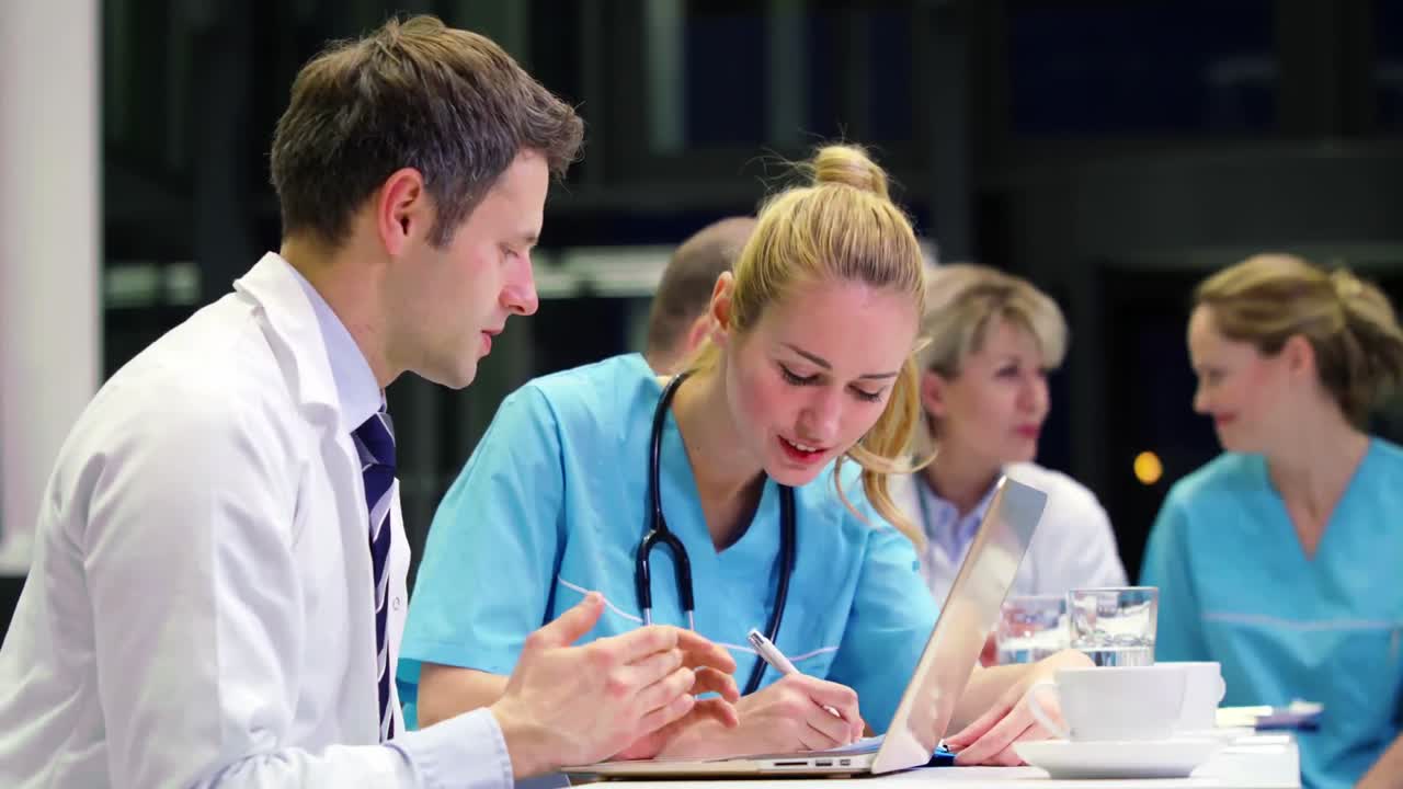 Medici e infermiera che discutono tra loro in sala conferenze