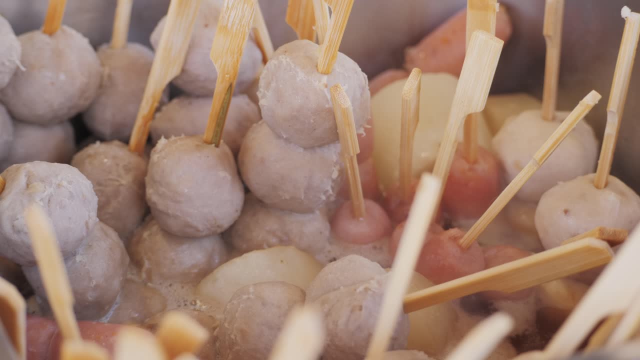 Making fruits in boiling caramel close-up. Chinese winter sweet dessert Tanghulu street food.Berries, grapes, tangerine and others fruit caramelized in sugar. Asian street market with traditional food.. High quality 4k footage
