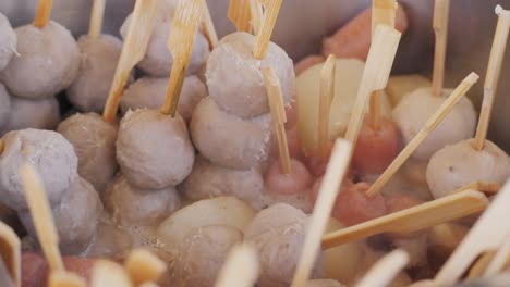 making fruits in boiling caramel close-up. chinese winter sweet dessert tanghulu street food.berries, grapes, tangerine and others fruit caramelized in sugar. asian street market with traditional food.. high quality 4k footage