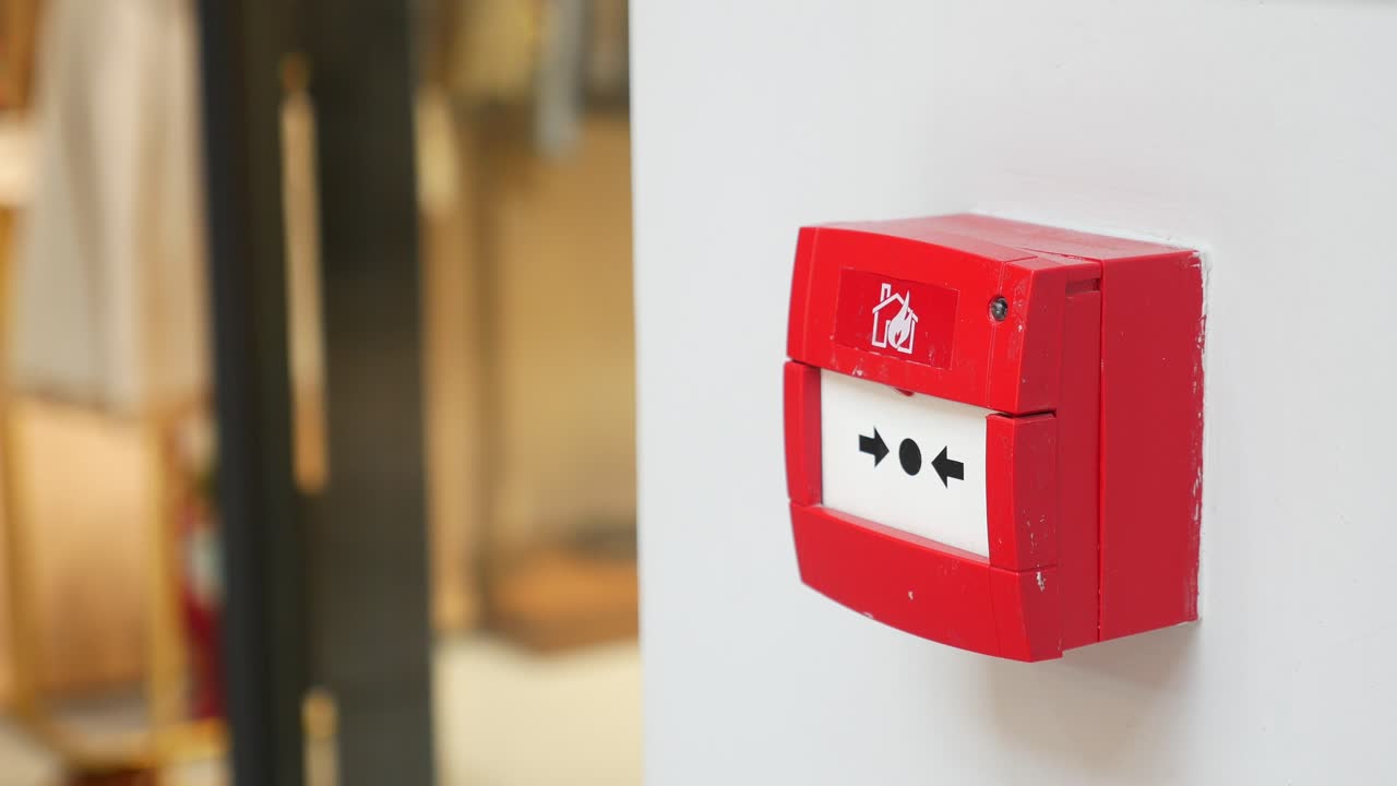 白い壁の赤い火災警報ボタン