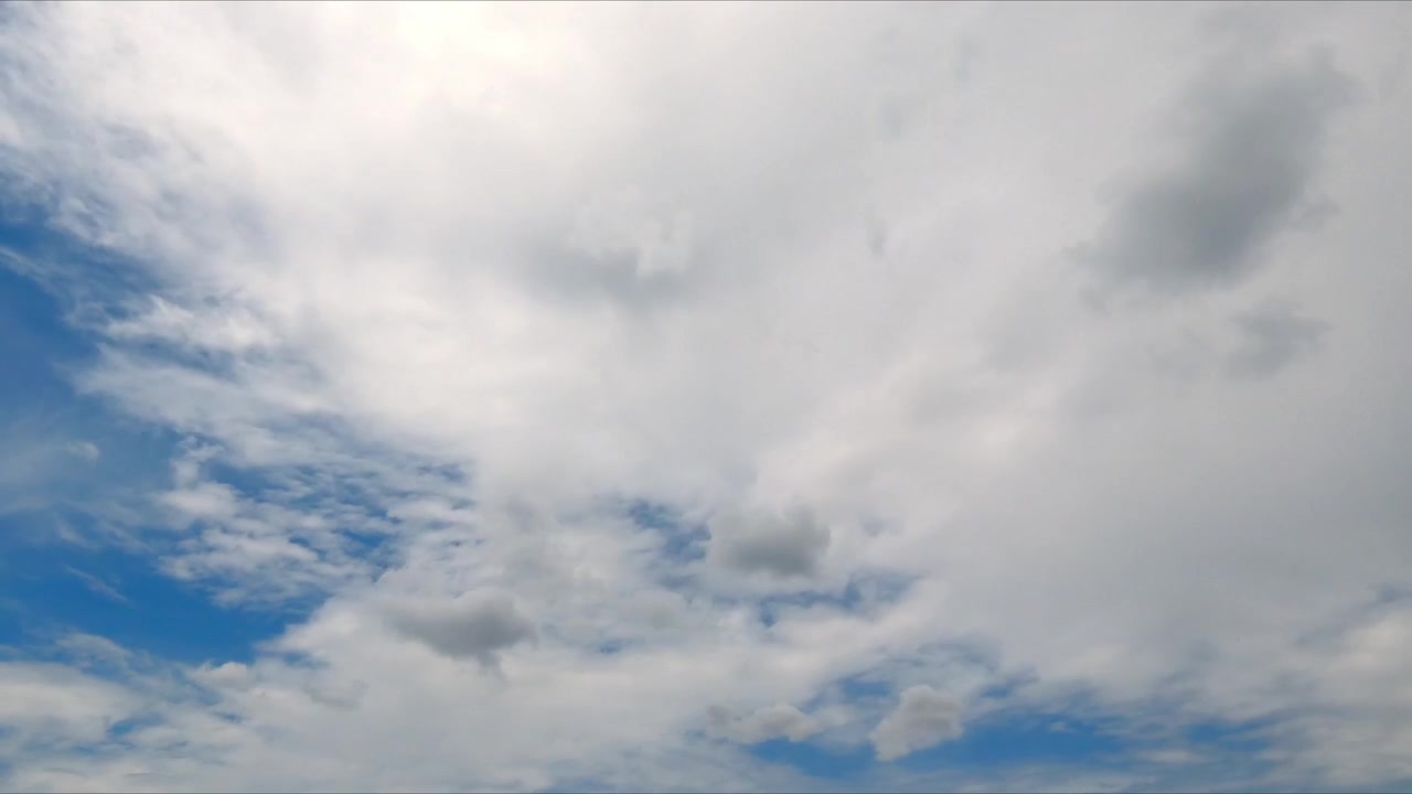 Timelapse of clouds drifting across a clear blue sky, capturing natural atmospheric motion and changing weather in a peaceful outdoor landscape.
