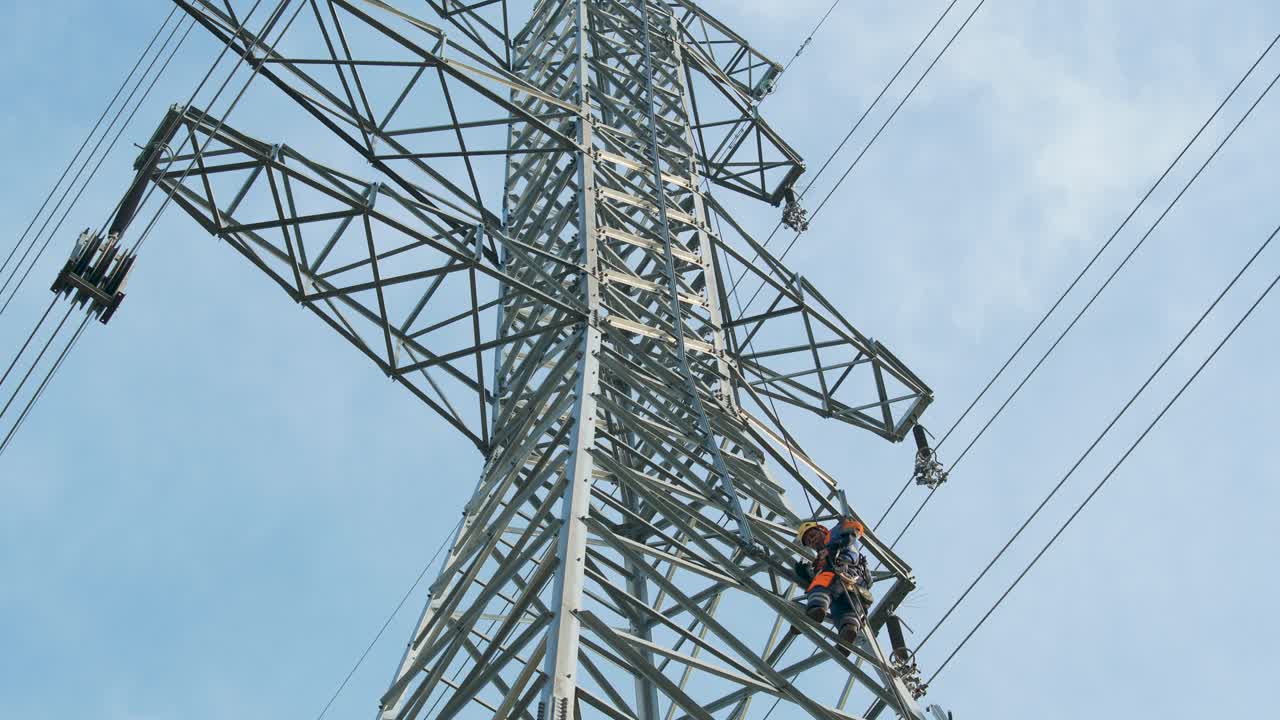 ingeniero eléctrico trabaja en lo alto de un poste de alta tensión