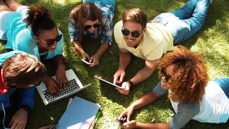 Group-of-friends-using-laptop,-mobile-phone-and-digital-tablet