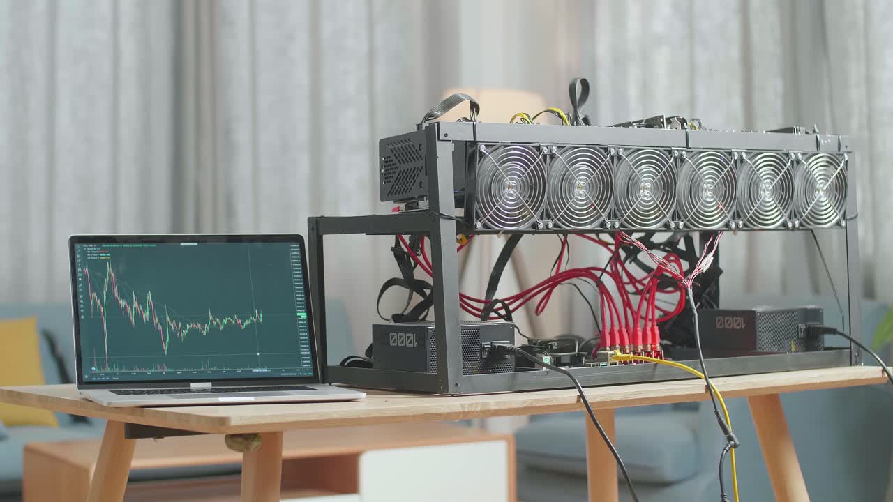 una computadora portátil que muestra un gráfico criptográfico está en la mesa con una plataforma de minería para la minería de criptomonedas