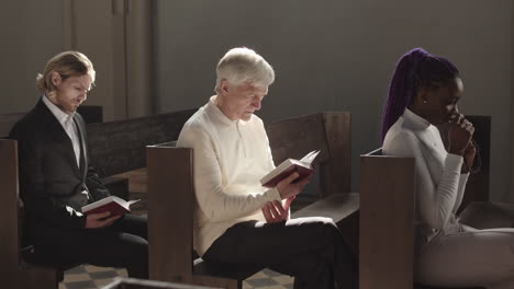 three multiethnic parishioners praying in catholic church