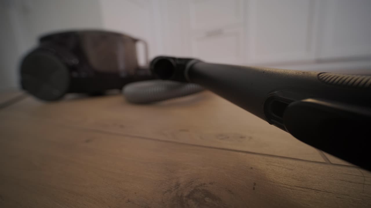 Vysavač pracuje na dřevěné podlaze.