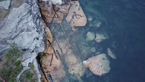 rocks at the bottom of a mountain cliff at balmoral beach, sydney - top view