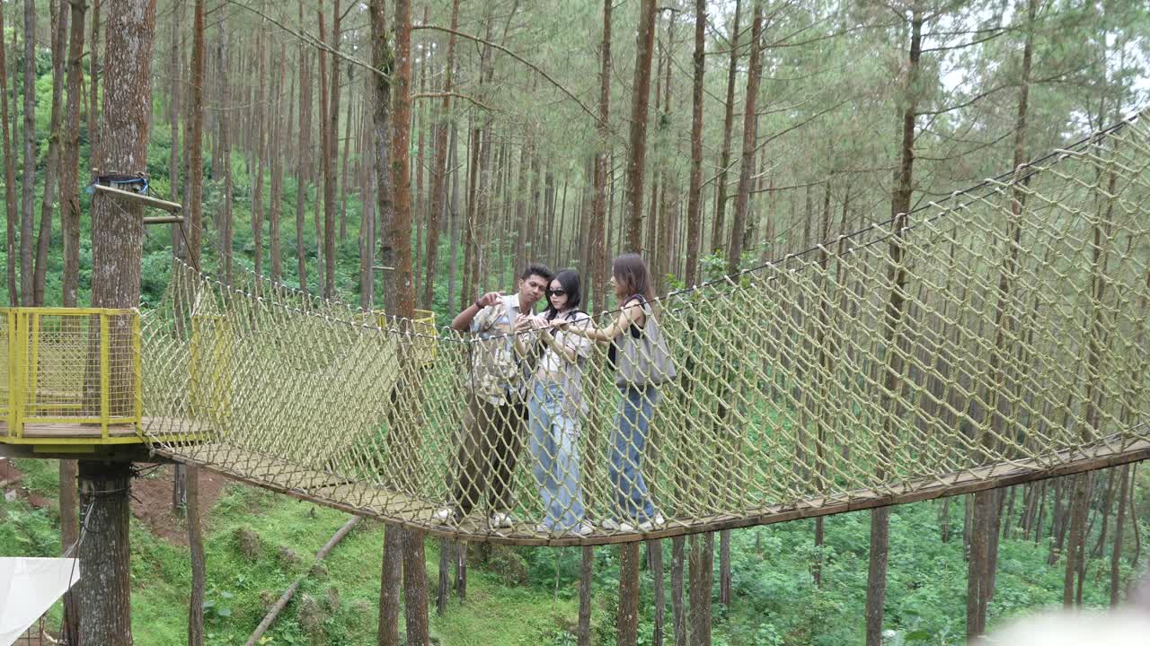 Asian Friends Taking Selfie on Forest Rope Bridge in Indonesia