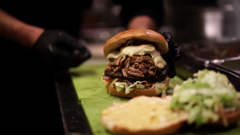 Guy-assembles-huge-and-greasy-burger-in-his-kitchen