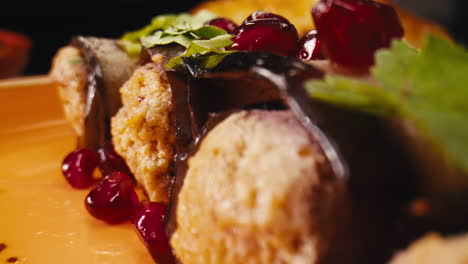 close-up of stuffed eggplant rolls with pomegranate