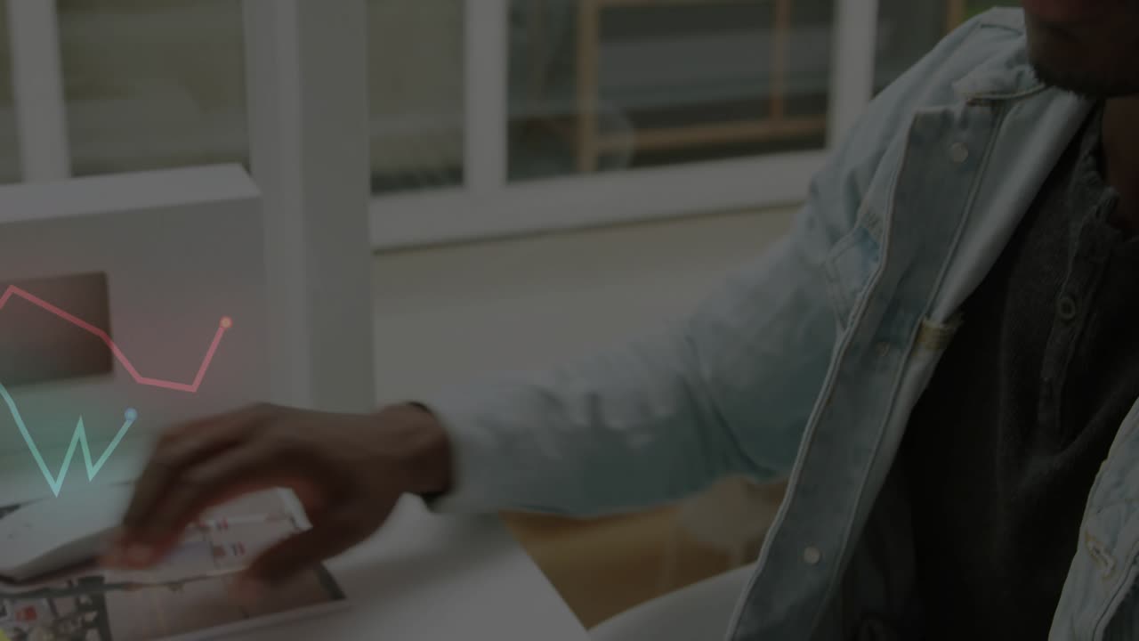 Office worker typing on wireless keyboard and generating red green data graphs for design review