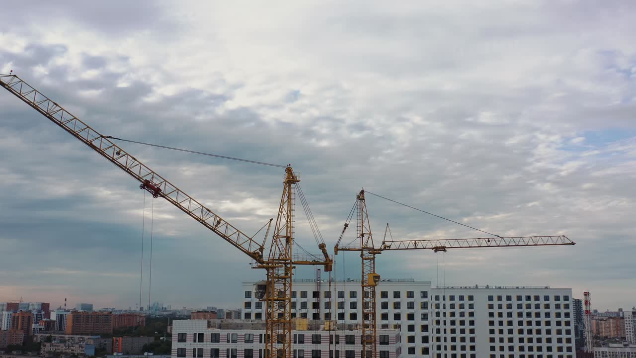 Residential complex under construction, building cranes pan circular shot