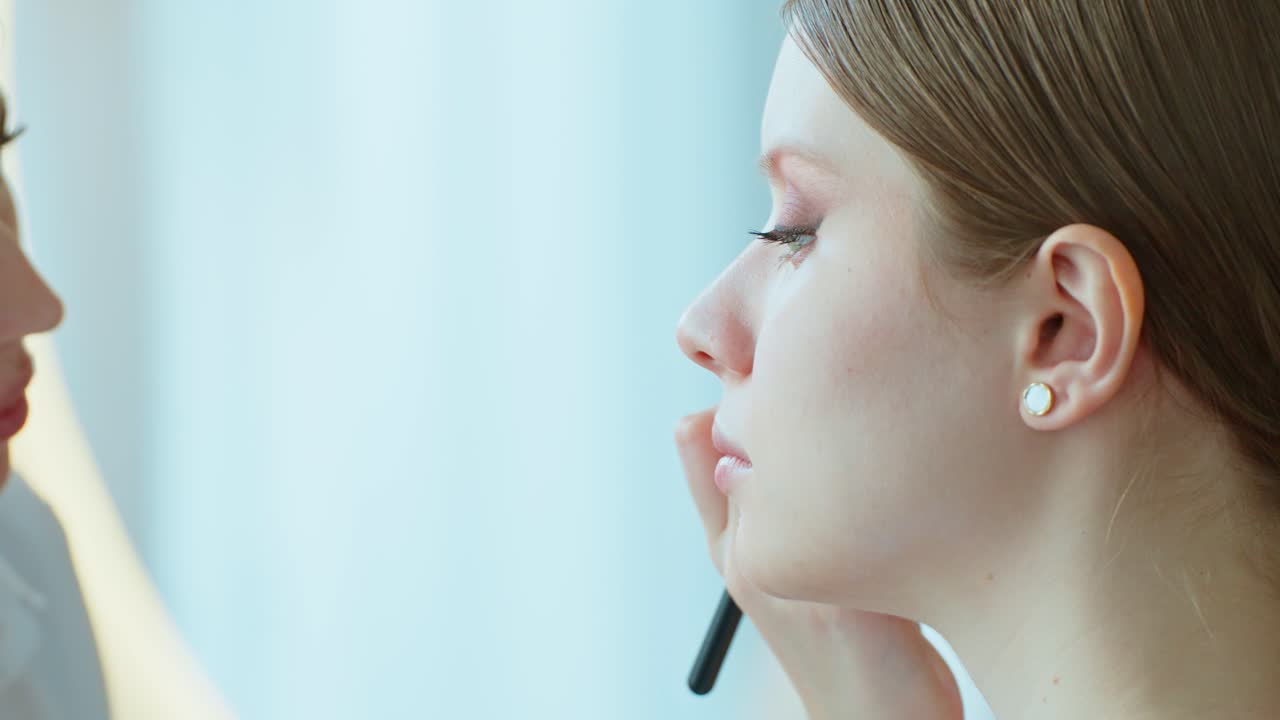 메이크업 아티스트 가 여자 에게 메이크업 을 하고 있다