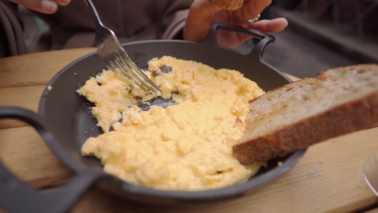 Close-up of Person Eating Scrambled Eggs with Toast