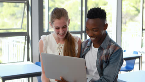 Students using laptop in classroom