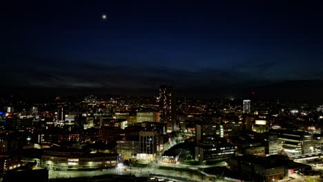 street traffic at night in central sheffield, uk, wide sinking aerial
