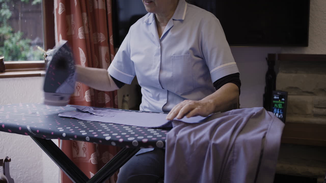 Woman ironing a shirt at home