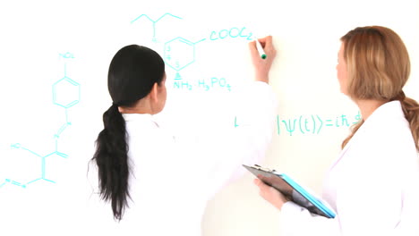 mujeres científicas escribiendo una fórmula