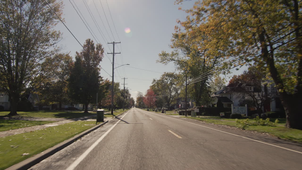 가을 하루에 경치 좋은 시골 도로를 달리는 pov view, 자동차의 뒷창에서 보는 전망.