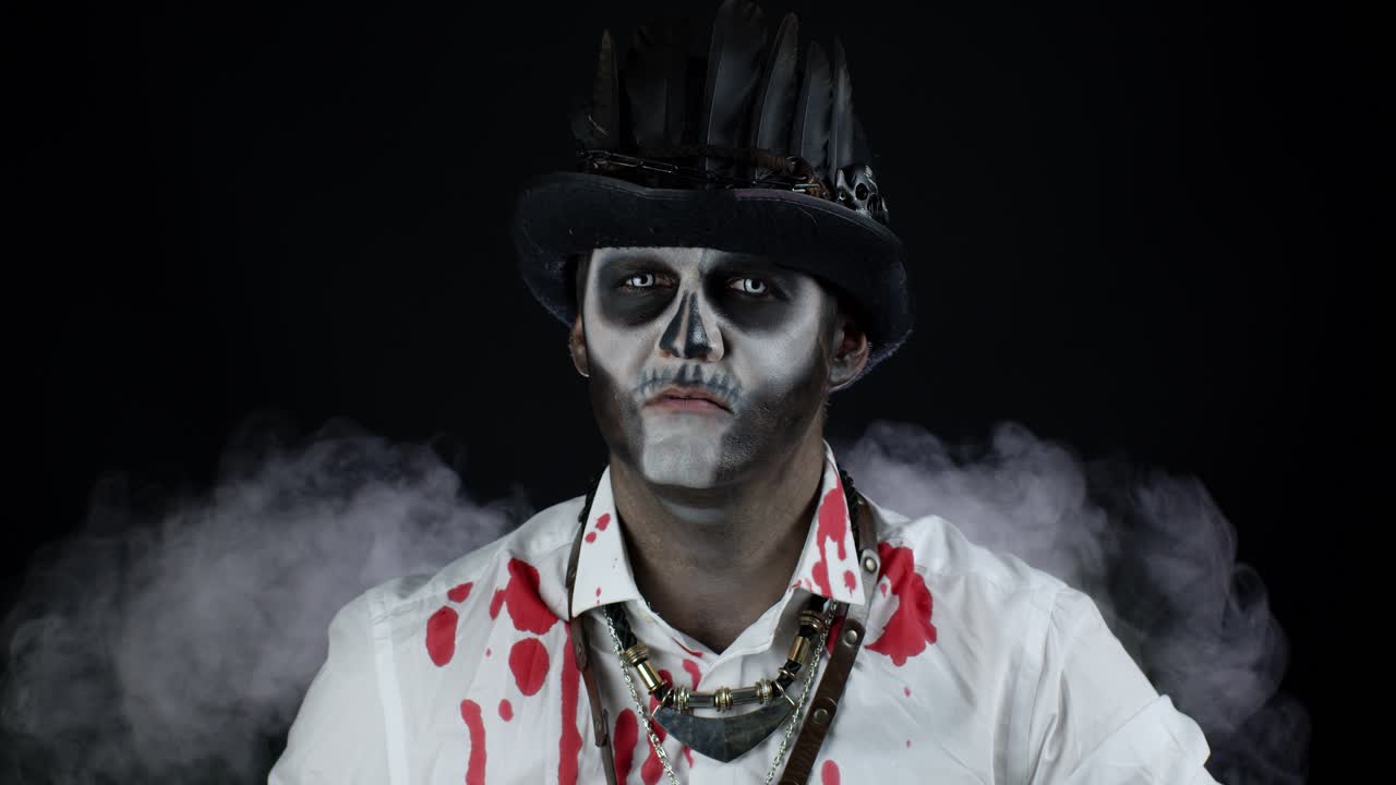 hombre espeluznante con maquillaje de esqueleto. tipo girando la cabeza y mirando a la cámara, tratando de asustar