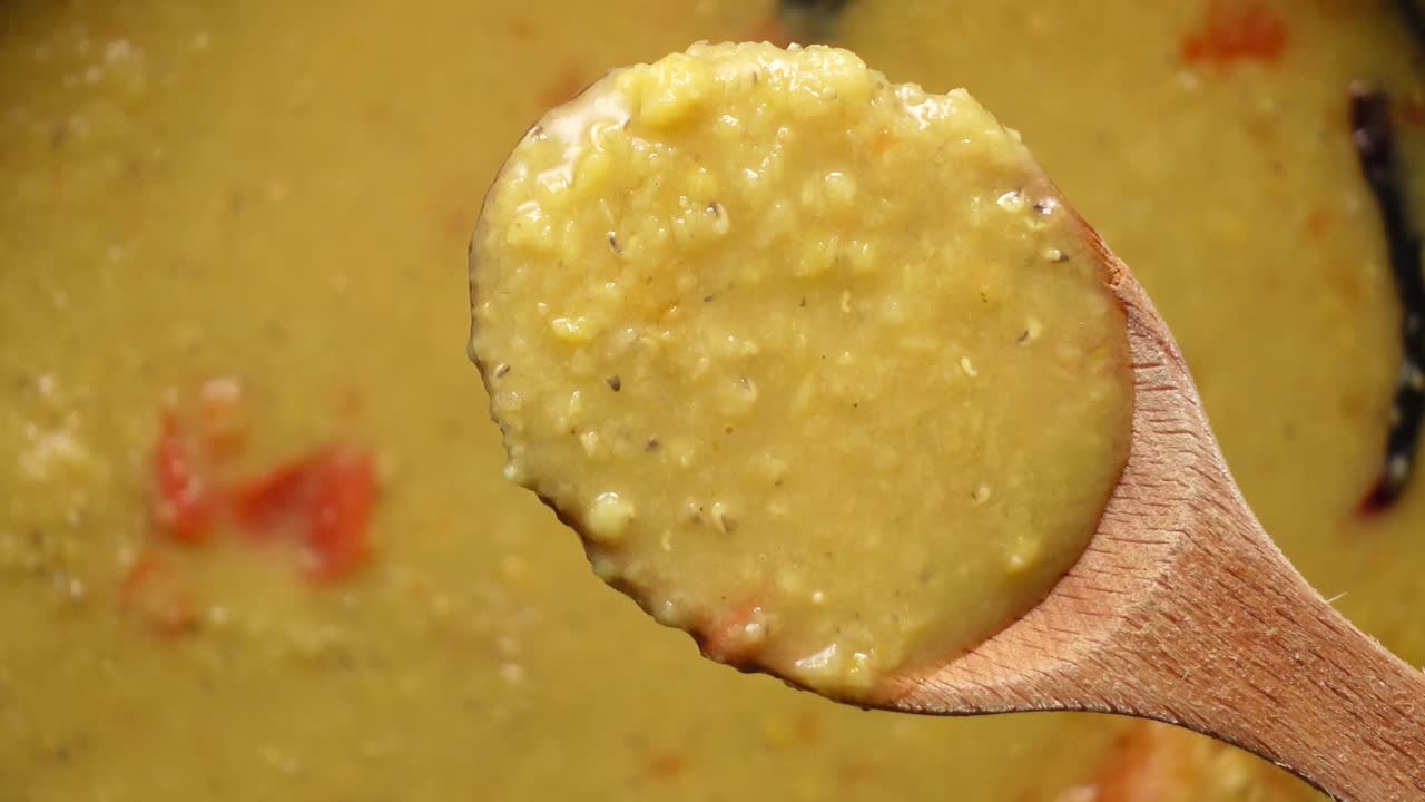 Close up of dal in a wooden spoon