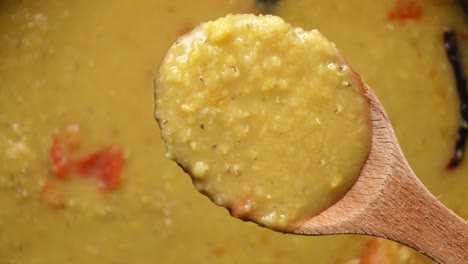 close up of dal in a wooden spoon