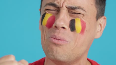 very nervous man supporting belgian team during a difficult match