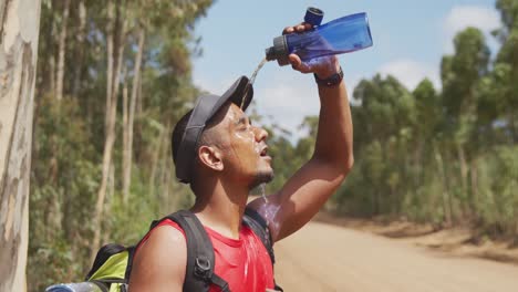 sporty mixed race man with prosthetic leg drinking water