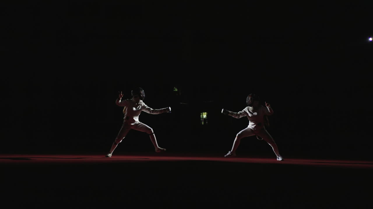Two fencers engage in a competitive match, showcasing their skills and athleticism