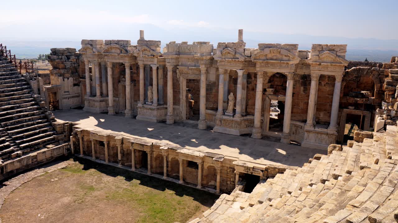 Stunning video of a Roman amphitheater at the ruins of Hierapolis, in Pamukkale, Türkiye. UNESCO world heritage. Video was made on sunny summer day.