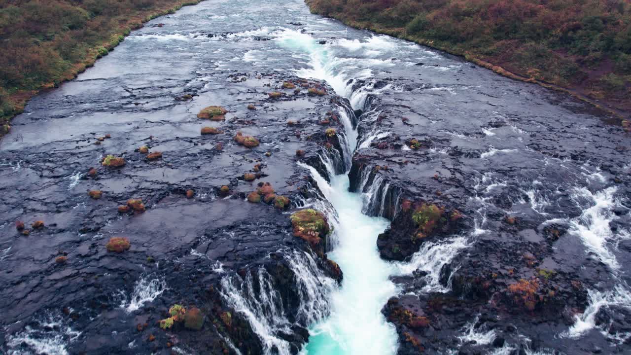 aerial: sobrevuelo bruarfoss cascada de agua fuera del círculo dorado en el sur de islandia que es muy pintoresco con la hermosa cascada azul de caídas en la piscina de inmersión debajo