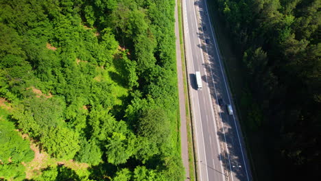 cars and vehicles passing on multi lane highway, forest and trees on both sides