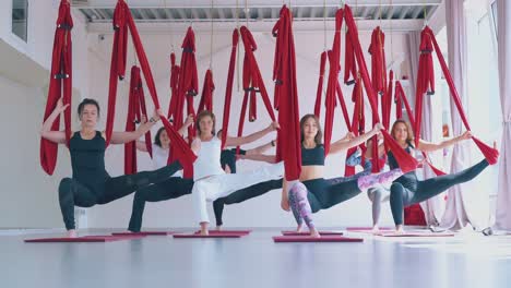 modern fly yoga zone with women standing in warrior asana