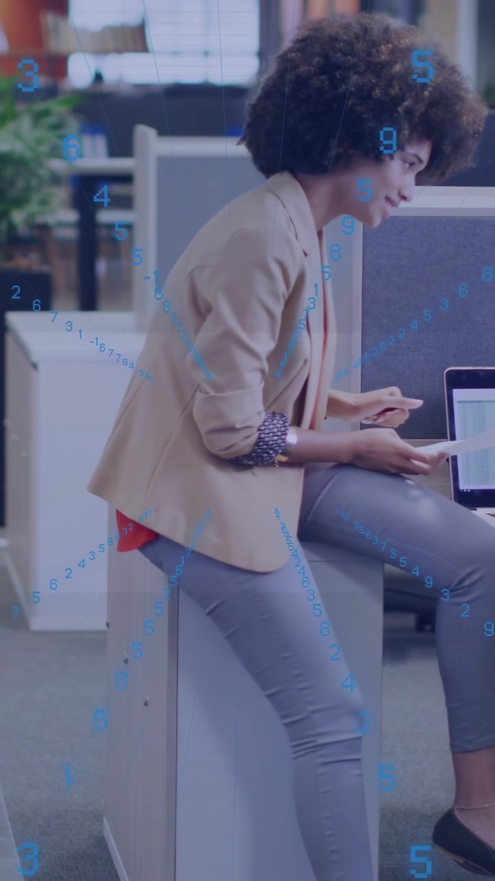 Vertical video: Woman offering pages at laptop, explaining business data, peer typing, blue overlay