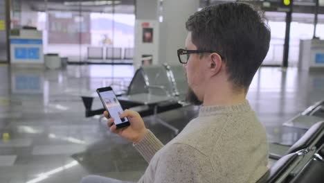 man using smartphone at airport