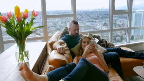 couple using digital tablet and mobile phone in living room 4k