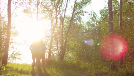 pareja de turistas caminando en el bosque al atardecer mientras camina hacia la cámara