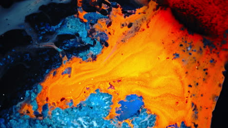 fiery orange ink flowing in water against rich blue tones, abstract macro shot