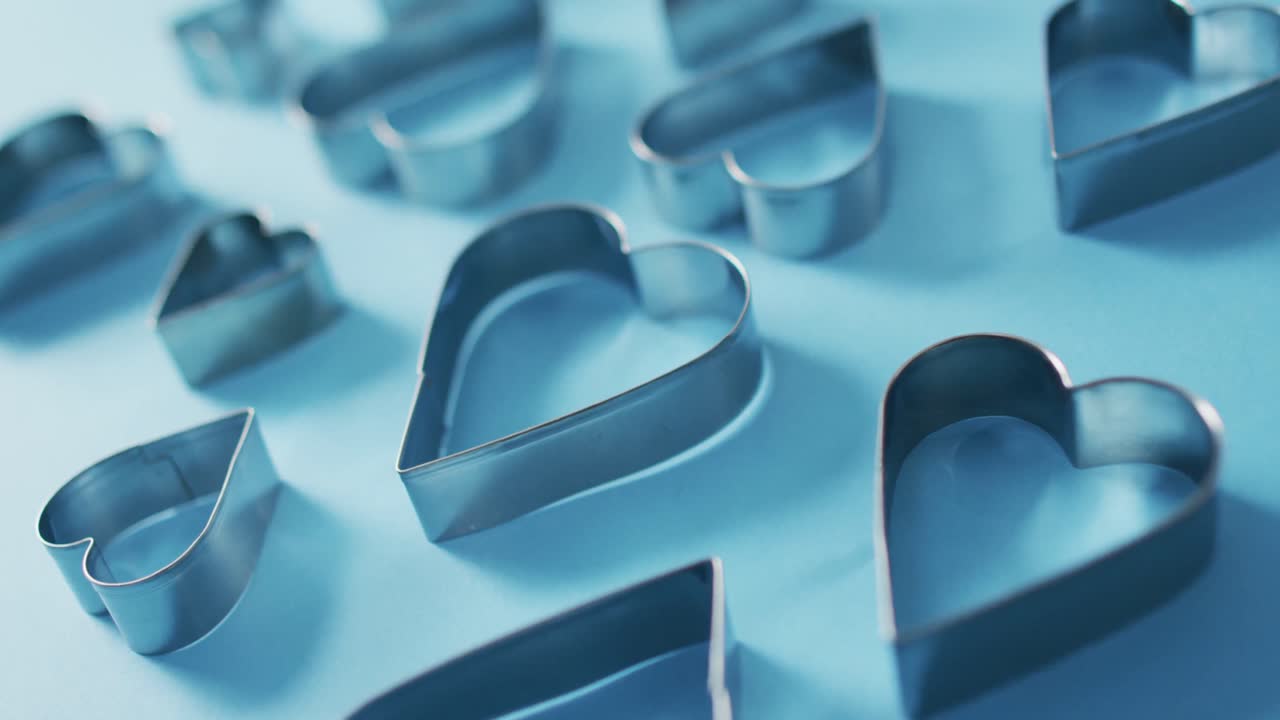 Heart shape cookie cutters on blue background at valentine's day