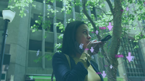 Globe-of-network-of-connections-against-woman-with-lowered-face-mask-talking-on-smartphone