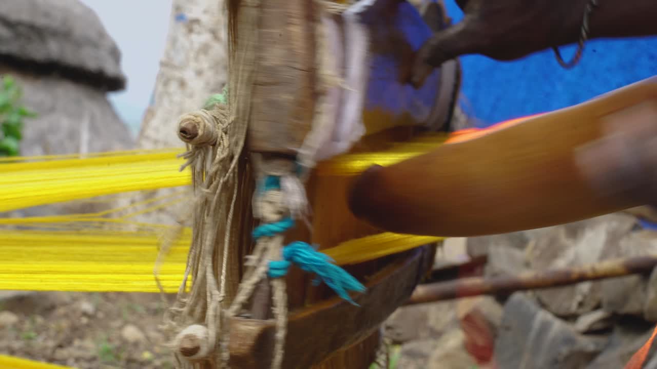 Tessitura su telaio in legno tradizionale nella città di Konso, Valle dell'Omo, Etiopia.