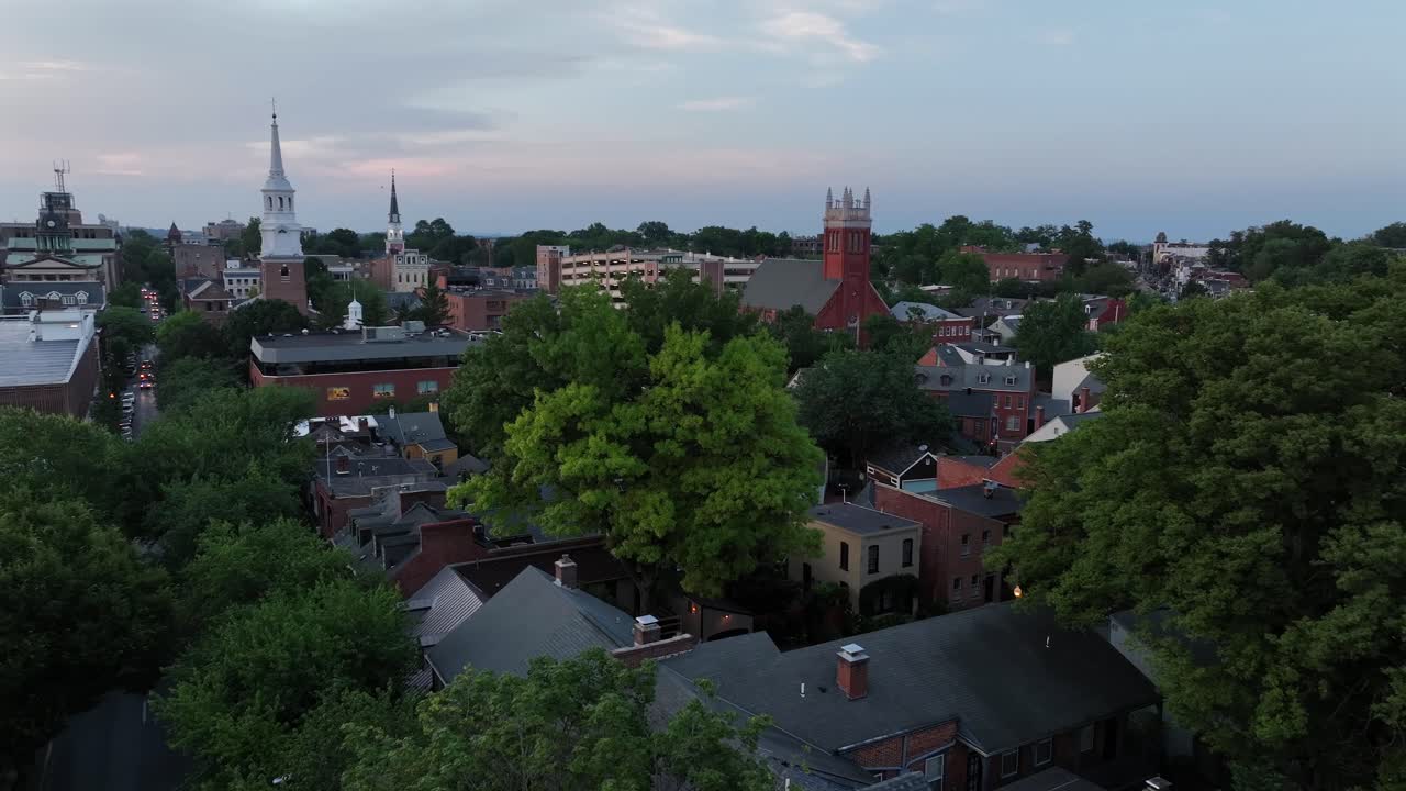 Historic cathedral and churches in downtown of Lancaster, Pennsylvania. Cloudy day in summer season with green blossoming trees. Wide shot. Drone flight. Apartment, houses and homes in center