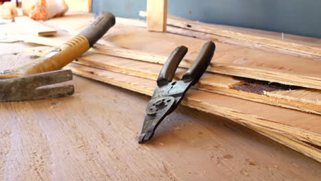 a set of electrician wire strippers and a hammer on the construction site of a new building