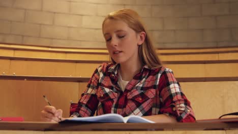 estudiante tomando notas en la clase